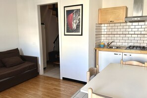A compact living space with a kitchenette, a dining area, and a sofa.
