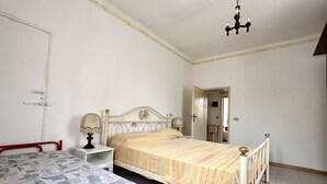Un dormitorio con cama, mesita de noche, lámpara y candelabro.