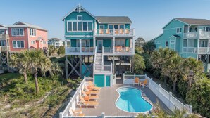 A multi-story building with a pool and outdoor seating. - Hobbs Realty - "All that Jazz" includes a private pool & panoramic views! (Holden Beach)