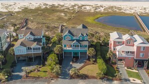 A coastal residential area with houses, a beach, and a pier. - Hobbs Realty - "All that Jazz" includes a private pool & panoramic views! (Holden Beach)