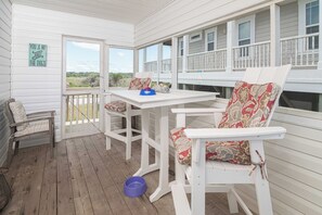 Relax in this serene outdoor seating area with a table, rocking chair, and beautiful views of the surrounding landscape.