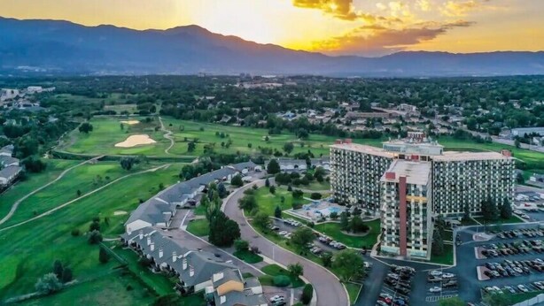 A high-rise hotel with a central courtyard, surrounded by green spaces and a golf course. - Quiet, Spotless Condo with King Bed for your Getaway! (Colorado Springs)