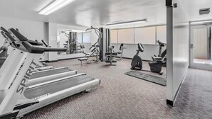 A modern gym with treadmills, elliptical machines, and weight equipment. - Quiet, Spotless Condo with King Bed for your Getaway! (Colorado Springs)