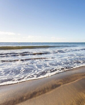 Een strand met golven die zachtjes op het strand spoelen.