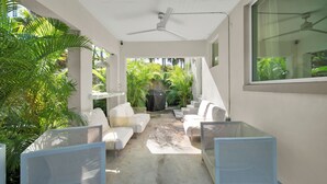 A covered outdoor seating area with white furniture and a ceiling fan. - Home LifeStyle Miami
Downtown and Miami Beach  (Miami)