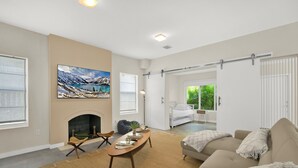 A modern living room with a fireplace, a large painting, a sofa, and a dining area. - Home LifeStyle Miami
Downtown and Miami Beach  (Miami)