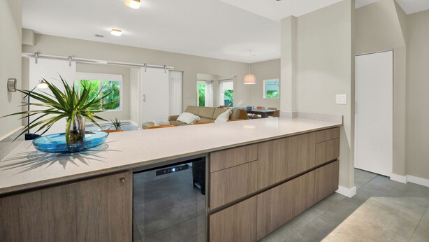 A modern kitchen with a large island, built-in appliances, and a view to the dining area. - Home LifeStyle Miami
Downtown and Miami Beach  (Miami)