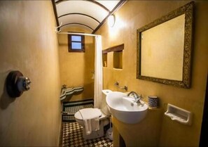 A compact bathroom with a white sink, a mirror, and a toilet. - Riad Arabella  (Fes)