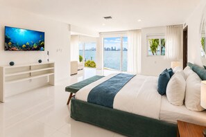 Un dormitorio moderno con una cama grande, televisión y vistas de la ciudad.