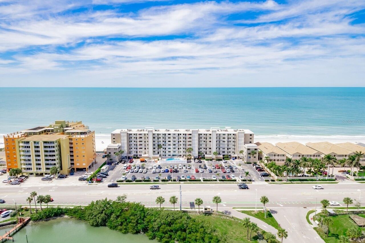 Un hôtel comprenant plusieurs bâtiments, un parking et offrant une vue sur la plage.