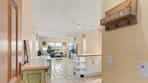 Un amplio espacio de sala con cocina, una mesa de comedor y un sofá. Hay un letrero que dice 'WELCOME'.