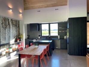 Enjoy meals in the kitchen with a central island, stove, and sink, adjacent to a dining area with a table and chairs.