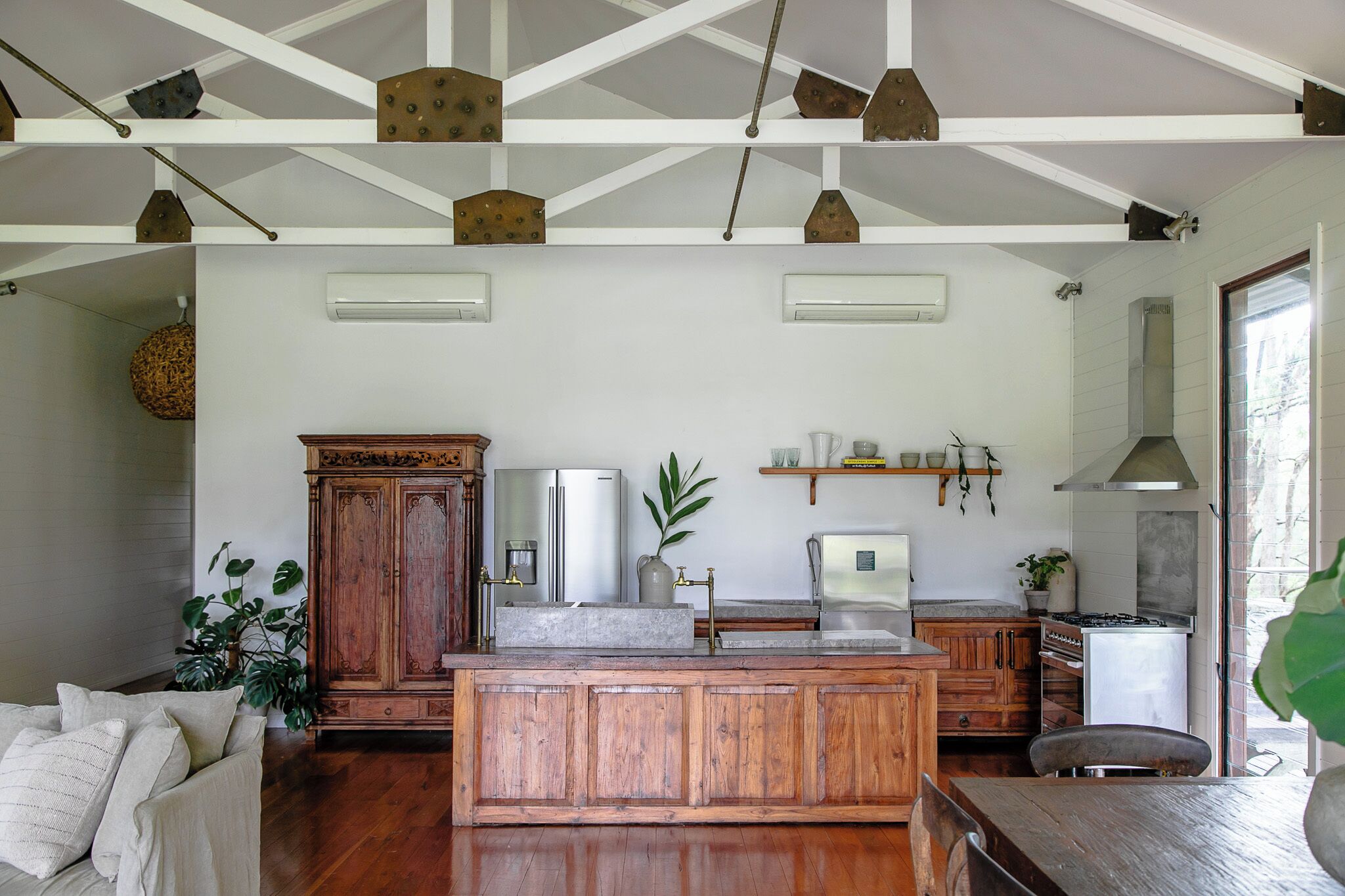 Une cuisine spacieuse avec des meubles en bois, un îlot central et un luminaire suspendu.