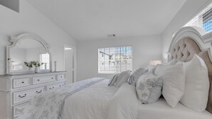 A bedroom with a large bed, a dresser, a mirror, and a window with blinds. - Bright, Spacious 2BD/2BA in the Heart of Hillcrest (San Diego)