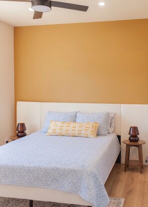 A bedroom with a bed, two bedside lamps, a ceiling fan, and a plain wall. - Desert Bliss - Stylish Kennewick Getaway (Kennewick)