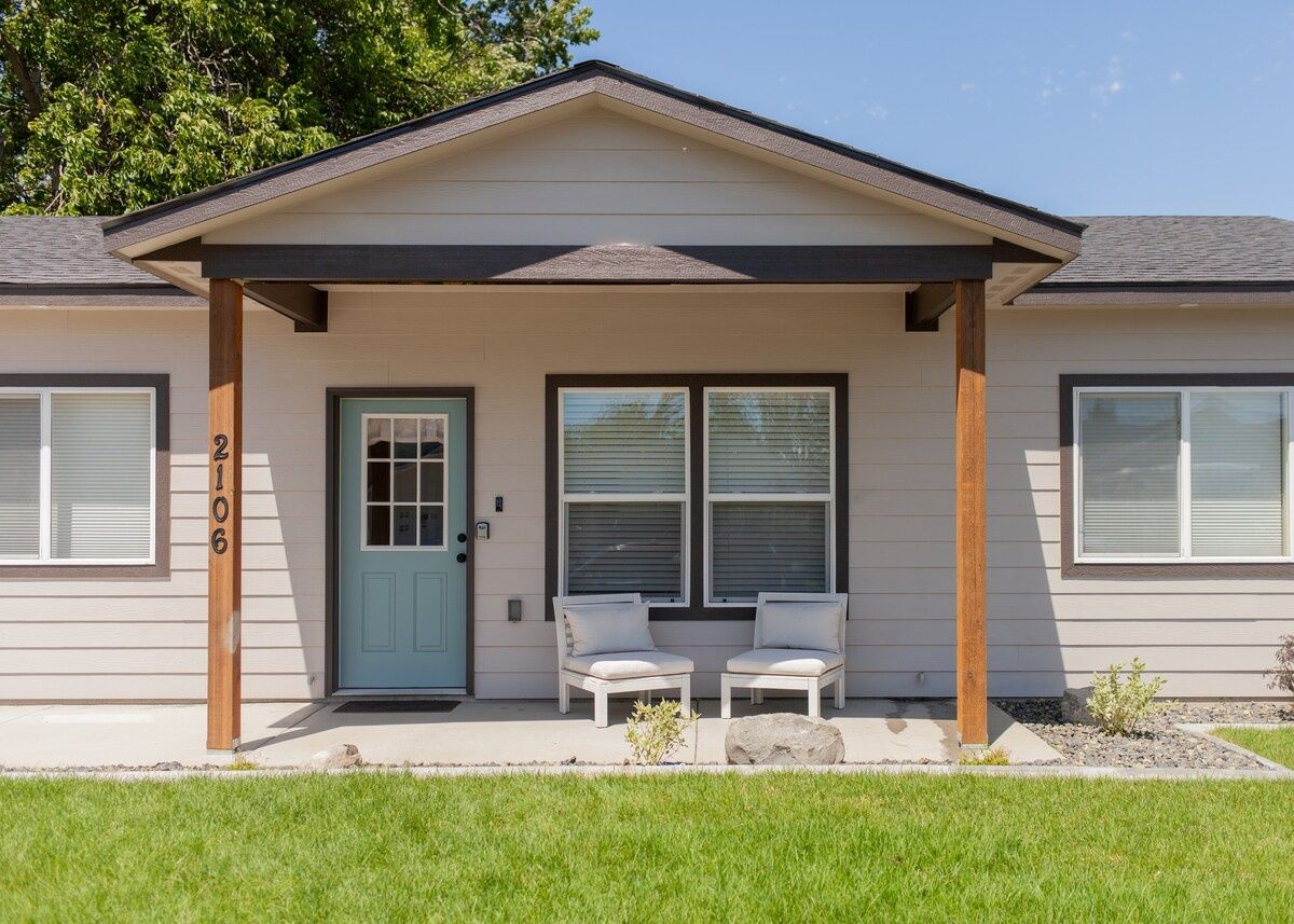A two-story house with a front porch, two windows, and a door.