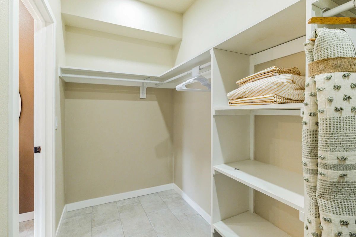 Spacious walk-in closet with shelving and hanging storage.