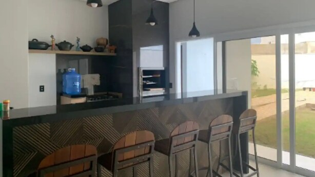 Eine moderne Küche mit Bar, großen Fenstern und Blick ins Freie.