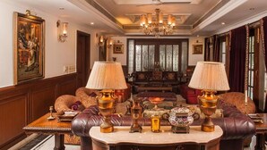 A luxurious room with a grand chandelier, leather sofas, and ornate lamps. - VILLA 33 Bed & Breakfast (New Delhi)