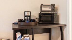 Una macchina del caffè e un forno a microonde su un tavolo.