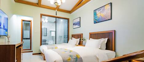 Quarto de hotel com teto de madeira, cama com roupa de cama branca, escrivaninha com cadeira e janela com persianas.