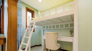 Un lit superposé avec un bureau et une chaise, une échelle en bois et une fenêtre avec des rideaux.