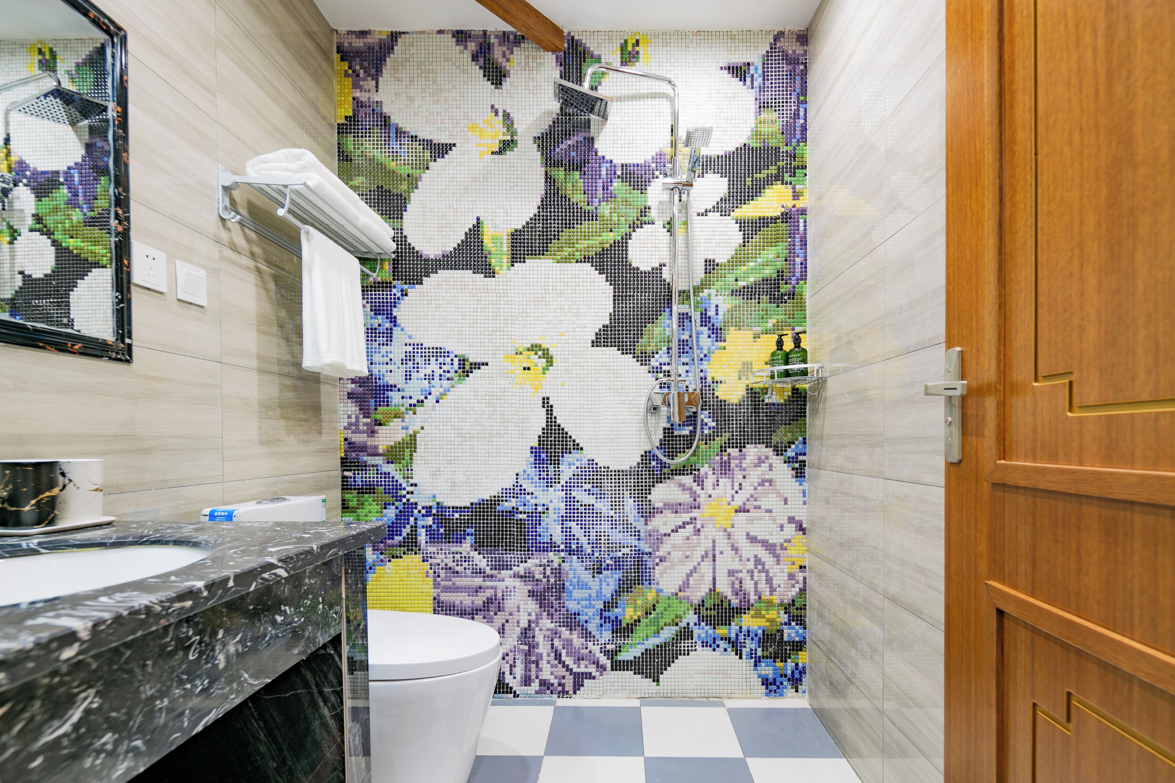 A bathroom with a tiled shower, a toilet, and a sink with a marble countertop.