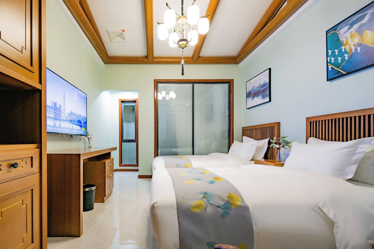 Ein Hotelzimmer mit einem Bett, einem Schreibtisch, einem Fernseher und einem Bild an der Wand.