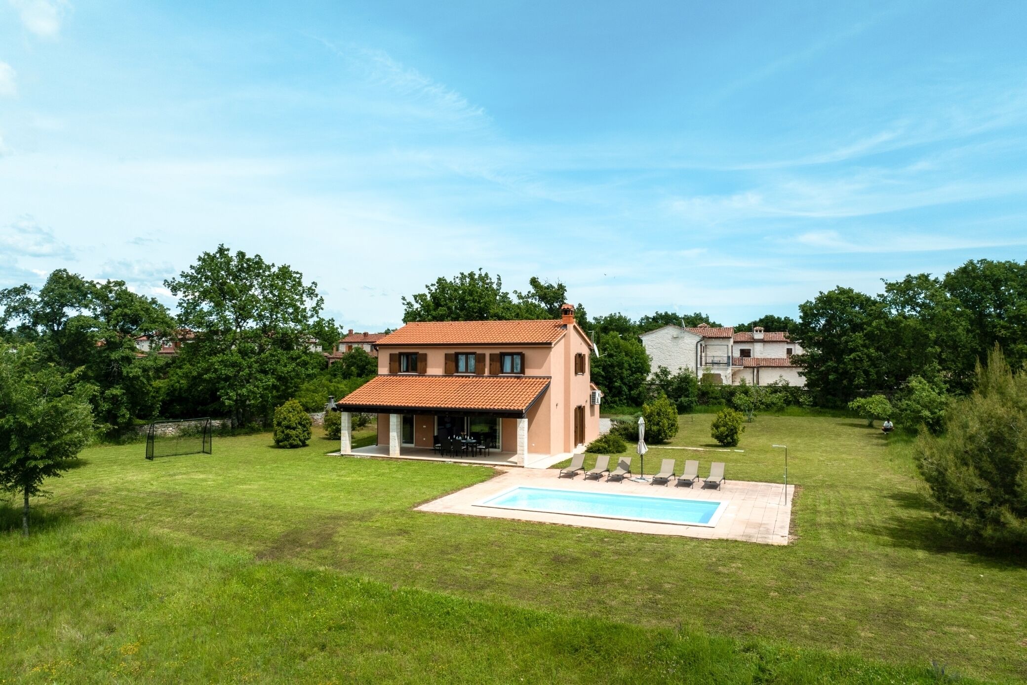 A two-story house with a swimming pool in the backyard.