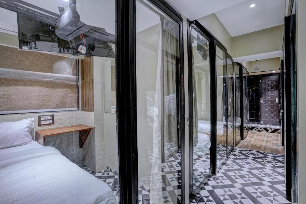 Quarto de hotel moderno com uma cama grande, uma prateleira de madeira e um painel de vidro.