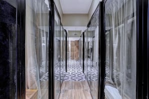 A corridor with glass doors leading to a room with a patterned floor. - Tokyo Stay Hostel (Mumbai)