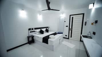 A modern hotel room with a bed, bedside table, and a ceiling fan.
