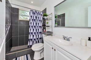 Une salle de bain moderne équipée d’une douche, de toilettes et d’un lavabo.
