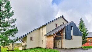 A modern two-story house with a sloped roof, a small porch, and a garage.