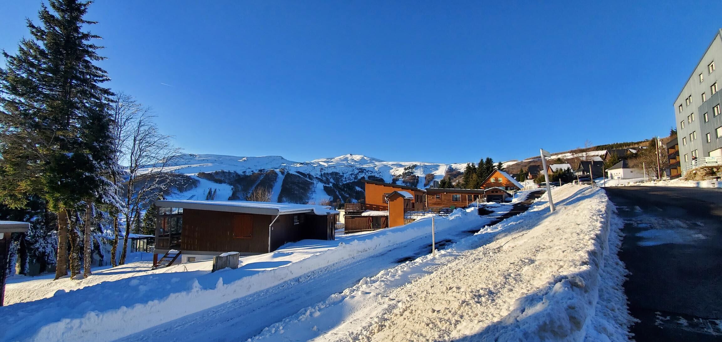 A snow-covered mountain town with buildings and a road.