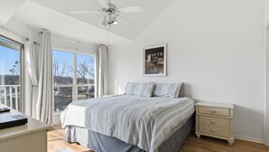 A bedroom with a bed, bedside table, and a ceiling fan. - Blue Oasis - Two Pools, Beach, & More! (Osage Beach)