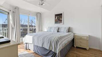 A bedroom with a bed, bedside table, and a ceiling fan.