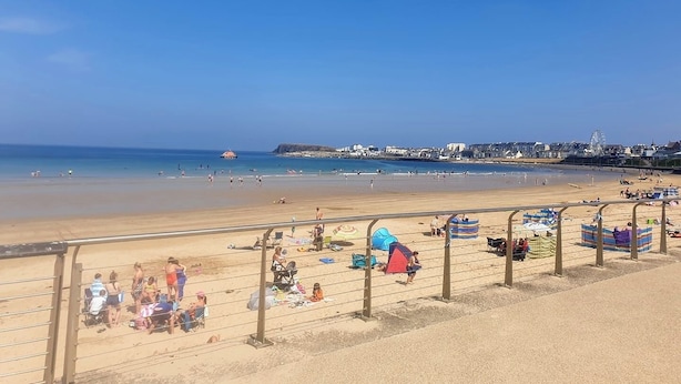 A beach with a clear sky, a sandy shore, and a distant cityscape. - Portrush Harbour Apt Walk to Beach (Portrush)