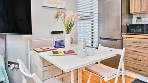 Une cuisine moderne avec une table blanche, un four à micro-ondes et des armoires en bois.