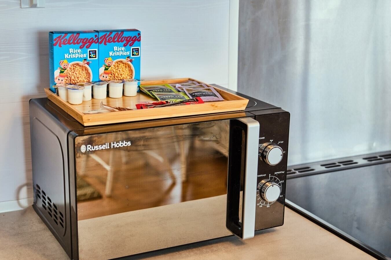 Ein Russell Hobbs Toaster mit einer Schale voller Kellogg's Rice Krispies-Schachteln und Milchbechern darauf.