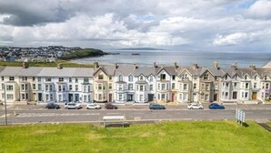 Filas de casas adosadas con vista al mar y una isla distante.