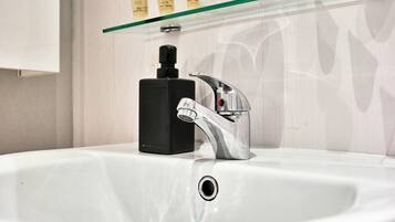 A bathroom sink with a modern faucet and a black soap dispenser.