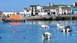 A harbor with boats and a waterfront building. - Victorian Apartment Steps to Beach (Portrush)