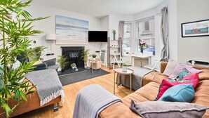 Ein modernes Wohnzimmer mit Kamin, Flachbildfernseher und Essbereich.