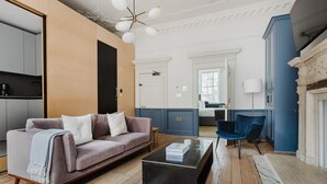 A modern living room with a sofa, a coffee table, and a blue chair.