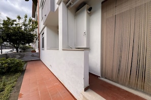 A building with a white exterior, a tiled patio, and a textured wall. - Amarea holiday home in Fuscaldo (Marina di Fuscaldo)