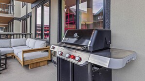 Eine Terrassenanlage im Freien mit eingebautem Grill und bequemen Sitzgelegenheiten.