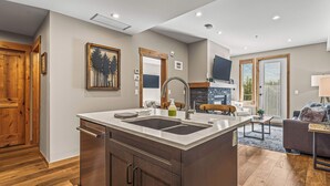 Una cocina moderna con una isla grande, armarios de madera y una estufa integrada.