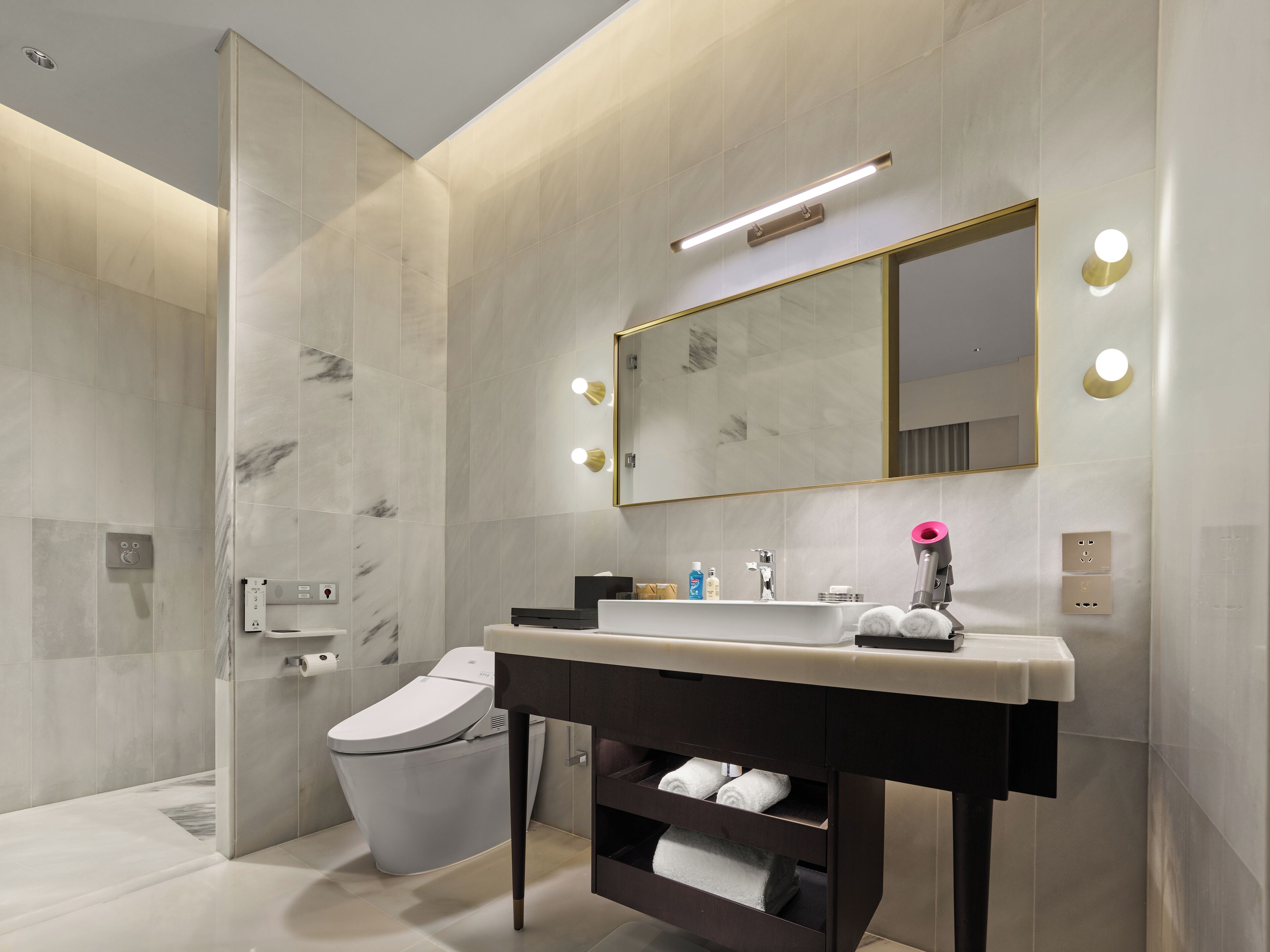 A modern bathroom with a marble shower, a toilet, a vanity with a mirror, and a towel rack.