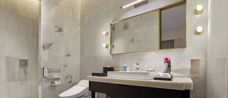 A modern bathroom with a marble shower, a toilet, a vanity with a mirror, and a towel rack.
